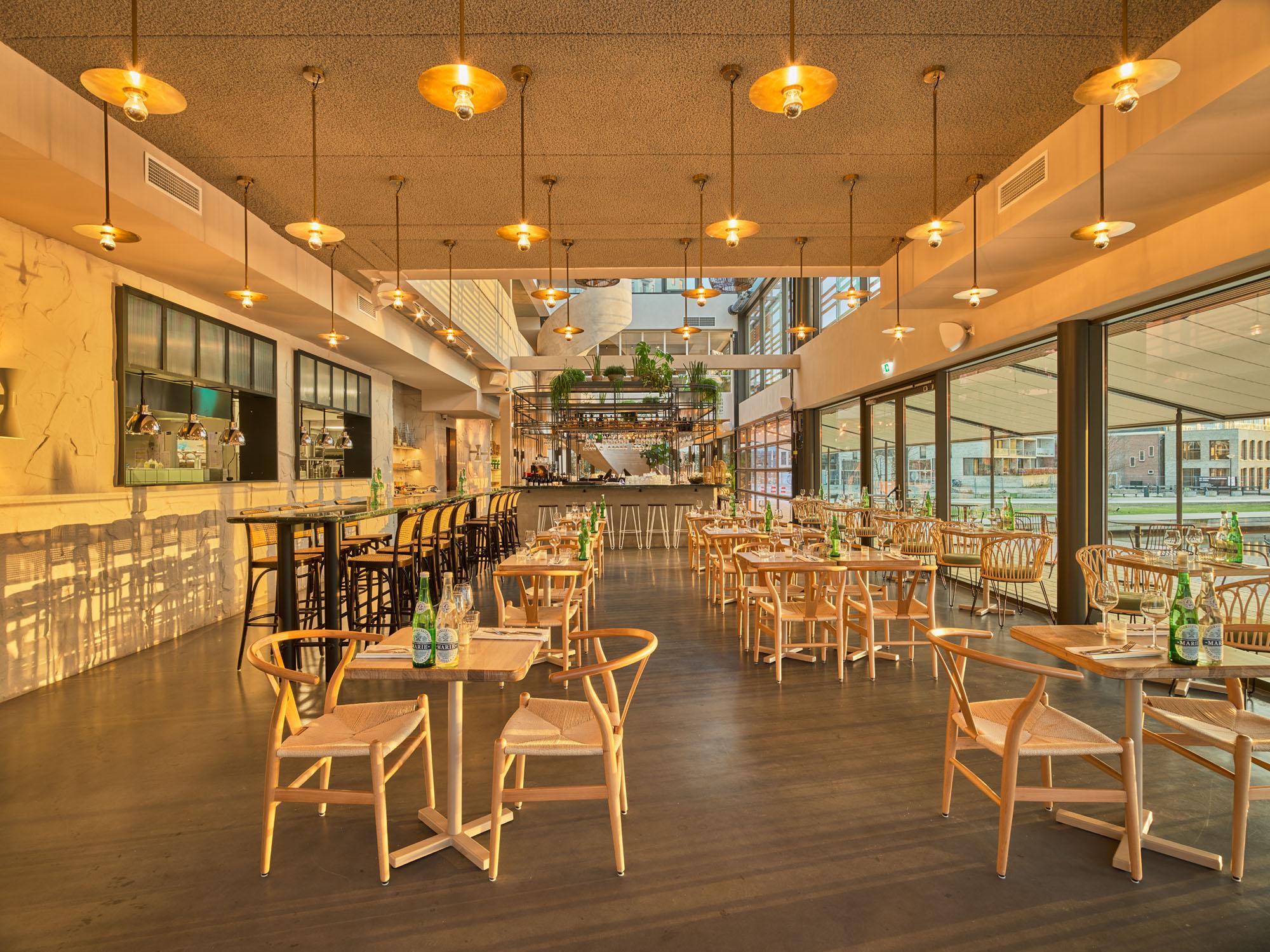 Restaurant George Marina in Amsterdam with Acosorb acoustic ceiling panels and warm lighting